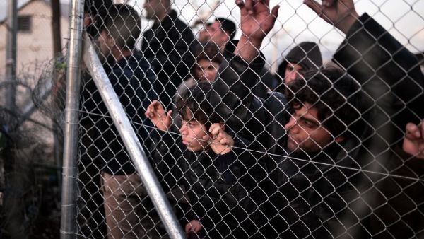 Refugees look through a fence towards the Macedonian side at the Greek-Macedonian border near the village of Idomeni on March 1 , 2016, where thousands are stranded. (AFP/Louisa Gouliamaki)