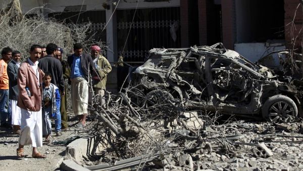 Yemeni men inspect damaged vehicles following an air-strike by the Saudi-led coalition in the capital Sanaa, on February 27, 2016. (AFP/Mohammed Huwais)