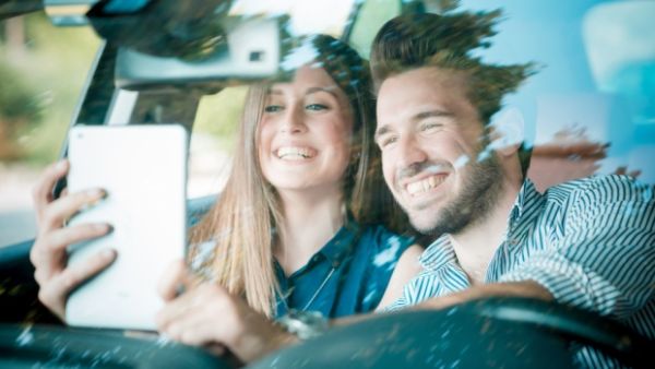 This selfie while driving could cost the couple a hefty fine and the seizure of their car! (Shutterstock)