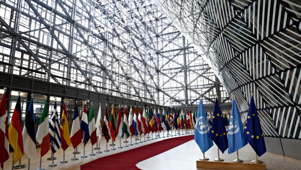 Flags of UN and EU stand in European council Building (Shutterstock)