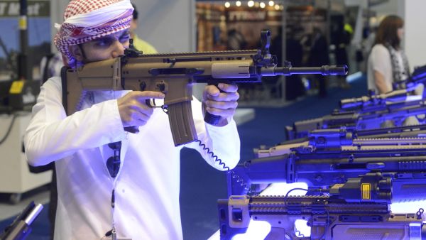 An Arab man in traditional clothes checks a new model of a machine gun visiting weapons exhibition. (Shutterstock/ File)
