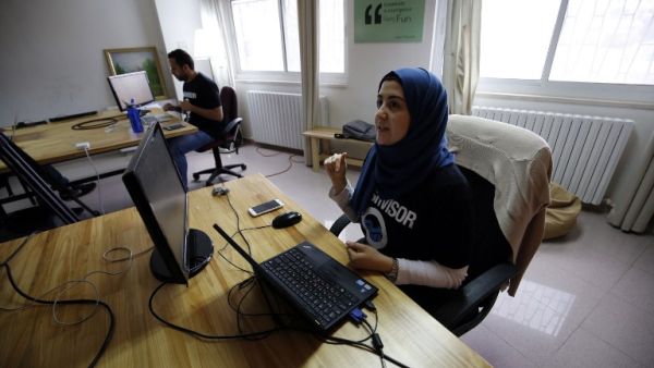 Palestinians work at the office of Red Crow, a startup that monitors security developments and sends real-time alerts to clients. (AFP/Abbas Momani) Palestinians work at the office of Red Crow, a startup that monitors security developments and sends real-time alerts to clients. (AFP/Abbas Momani)