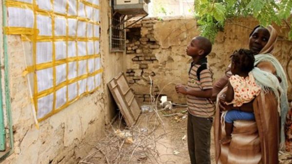 عائلة سودانية تراجع لائحة ناخبين خلال جولة اعادة انتخابية في بعض الولايات/أ.ف.ب