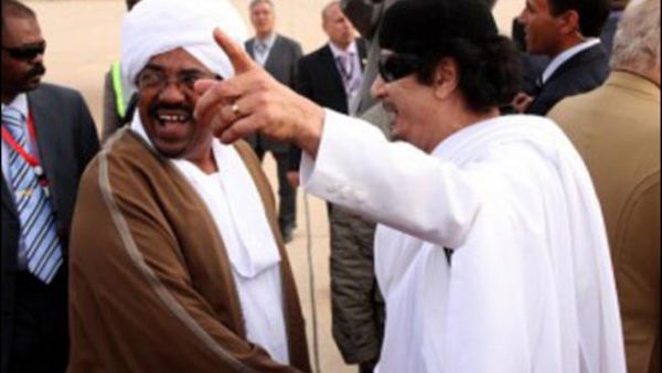 القذافي مستقبلا البشير خلال زيارة سابقة