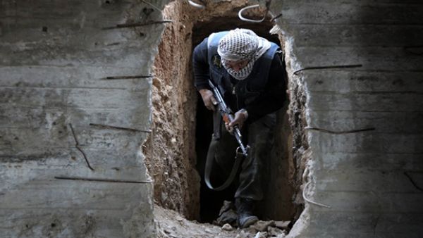 A Syrian rebel fighter from the Failaq al-Rahman brigade comes out of a hiding position on the frontline against regime forces in the town of Arbin in the eastern Ghouta region on the outskirts of the capital Damascus. (AFP/File)