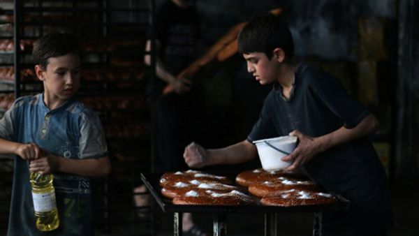 Syrian children help to prepare bread at a bakery in the rebel-held side of the northern city of Aleppo as Muslims get ready for Iftar during the holy month of Ramadan. (AFP/File)