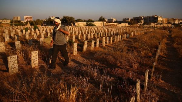 A Syrian man visits the graves of loved ones at a cemetery in the rebel-held area of Douma, east of the capital Damascus, on July 19, 2015. (AFP/Abd Doumany) 