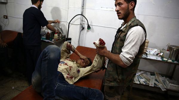 A wounded Syrian boy awaits treatment by doctors at a makeshift hospital in the rebel-held area of Douma, east of the capital Damascus, following reported air strikes on the city on May 11, 2015. (AFP/Abd Doumany)