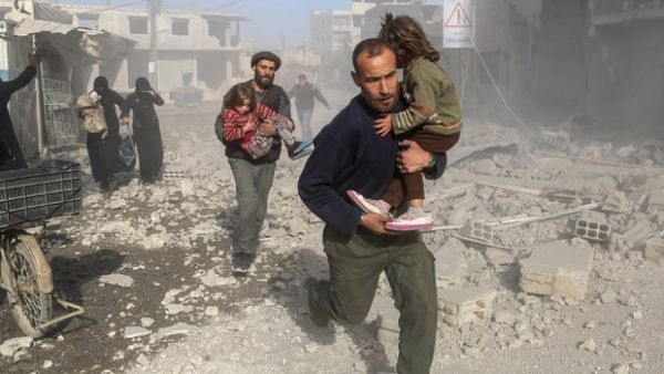 Syrians make their way through debris in Eastern Ghouta (AFP/File Photo)