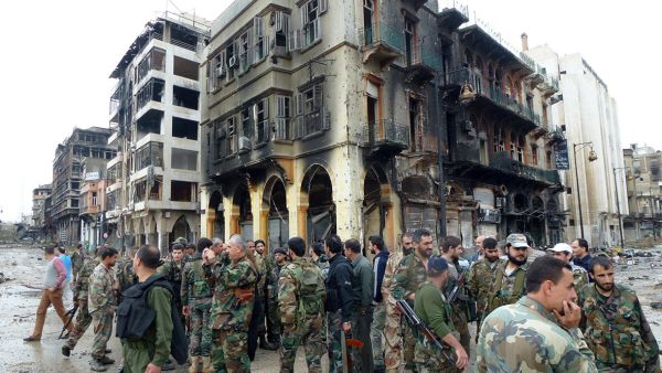 Syrian army soldiers survey the damage to buildings in the embattled city of Homs. (AFP/File) Syrian army soldiers survey the damage to buildings in the embattled city of Homs. (AFP/File)