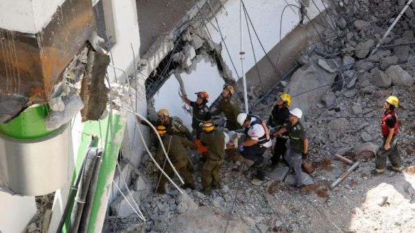 Israeli medics and emergency units carry respond to the scene of a collapsed car park in Tel Aviv on September 5, 2016. (AFP/Gil Cohen-Magen)