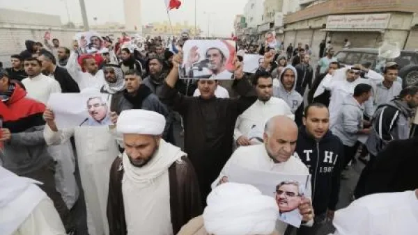 محتجون يحملون صورا للشيخ علي سلمان زعيم جمعية الوفاق أثناء مظاهرة في المنامة
