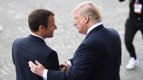 French President Emmanuel Macron (L) bids farewell to his US counterpart Donald Trump (AFP/File Photo)