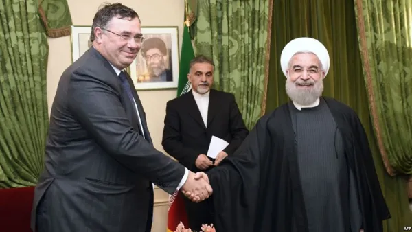 Total Chief Executive Officer Patrick Pouyanne (L) shakes hands with Iranian President Hassan Rouhani during a meeting in Paris on January 28, 2016. (Eric Fefferberg/ AFP)