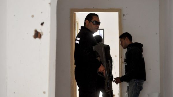 Tunisian gendarmes walk inside a house where two suspected jihadists were killed during a security operation on May 11, 2016 in the town of Mnihla, in Ariana province just outside Tunis. (AFP/Fethi Belaid)