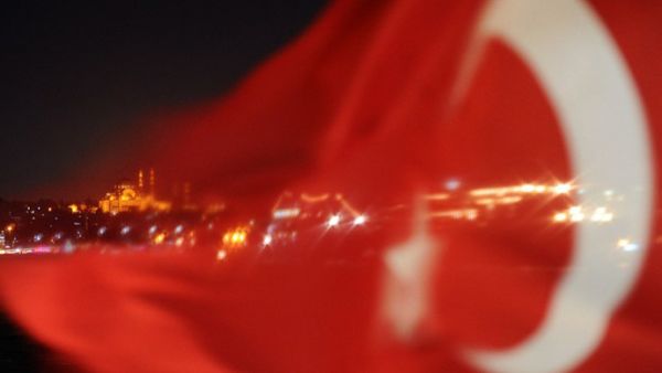The Turkish flag is seen in front of Istanbul's skyline.  The Turkish government's decision to demolish an Izmir football stadium - once the gathering place of a diverse array of ethnic groups - recalls frightening memories of ethnic cleansing at the hands of the Ottoman Empire a century ago.  (AFP/Bulent Kilic)