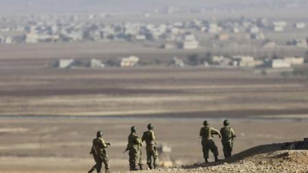 جنود اتراك يتابعون المعارك الدائرة في كوباني على الجانب المقابل من الحدود في سوريا