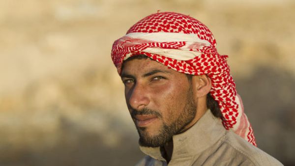 Bedouin camel herder wears a shemagh at sunset in Jordan (Shutterstock/Martin Good)