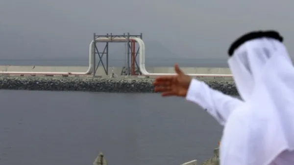 An Emirati man stands in front of a pipeline at the oil terminal of Fujairah during the inauguration ceremony of a dock for supertankers on September 21, 2016. (Karim Sahib/ AFP)