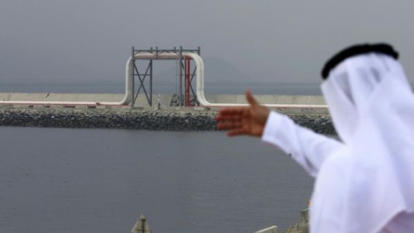 An Emirati man stands in front of a pipeline at the oil terminal of Fujairah during the inauguration ceremony of a dock for supertankers on September 21, 2016. (Karim Sahib/ AFP)