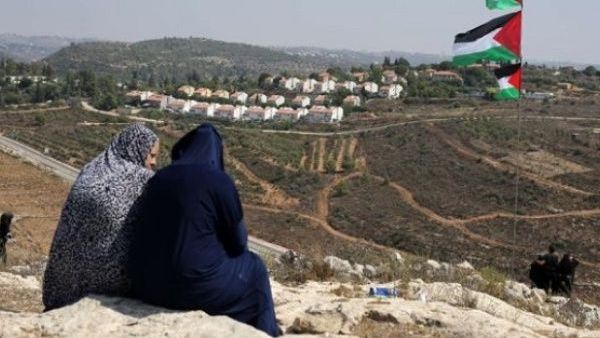 Two Palestinian women gaze at the Jewish Hallamish settlement in the West Bank village of Nabi Saleh (AFP/File Photo)	