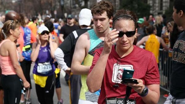 A woman reacts after two explosions rock the Boston Marathon (AFP/ Alex Trautwig)