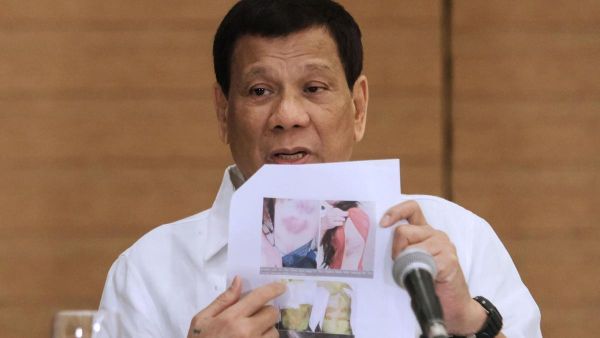 Philippine President Rodrigo Duterte shows a photo of a Filipina worker in Kuwait, who he said had been abused by her employer (AFP/File Photo)