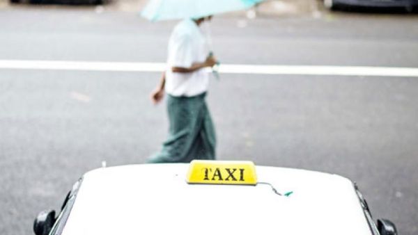 A man walks past a parked taxi (AFP/File Photo)