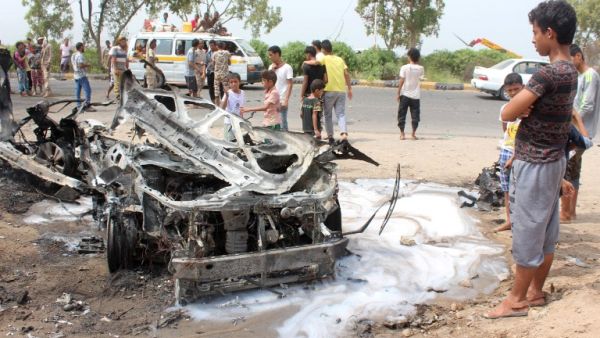 Yemenis inspect a charred vehicle following a suicide car bombing attack that targeted the convoy of Aden's governor, in the southern city of Aden on July 15, 2016. (AFP/Saleh al-Obeidi)