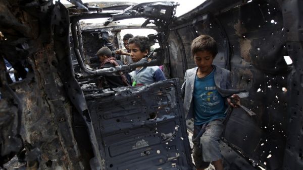 Yemeni children inspect a charred vehicle on September 9, 2016 after two improvised explosive devices (IEDs) went off inside a car in the capital Sanaa. (AFP/Mohammed Huwais)