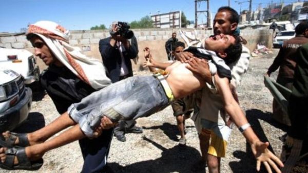 أشخاص يسعفون جريحا أصيب خلال المواجهات بين المتظاهرين والأمن في صنعاء 