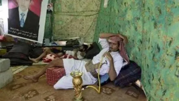 يمني يدخن الارجيلة داخل خيمة في ساحة الاعتصام في صنعاء