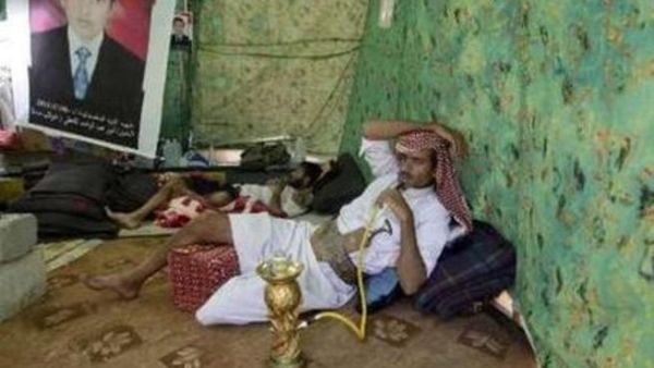 يمني يدخن الارجيلة داخل خيمة في ساحة الاعتصام في صنعاء