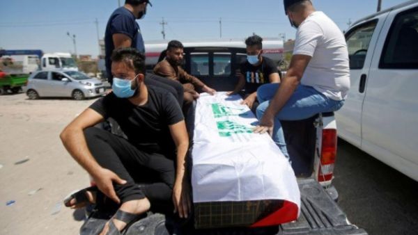 مشيعون يجلسون أمام نعش الناشطة العراقية ريهام يعقوب خلال جنازتها في البصرة