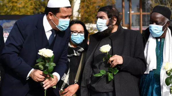 حسن شلغومي (يسار) والكاتب اليهودي الفرنسي ماريك هالتر (الثاني من اليمين) أثناء تجمع لأئمة أمام مدرسة في ضاحية باريس كان يعلّم فيها المدرس الفرنسي صامويل باتي الذي قُطع رأسه بسبب عرضه على تلاميذه رسوماً تُظهر النبي محمد.