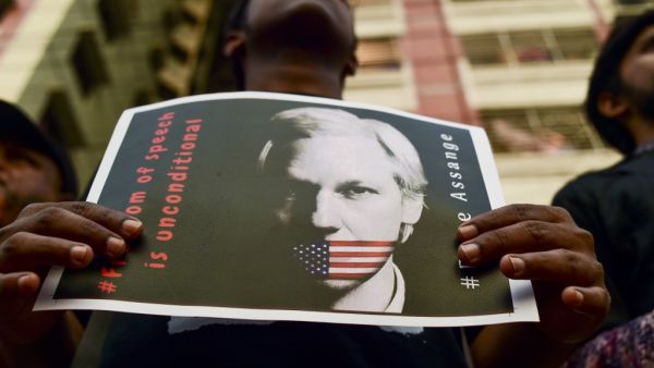 An activist holds a placard next to others while forming a human chain calling for the freedom of the international non-profit organisation"WikiLeaks" founder Julian Assange (AFP)
