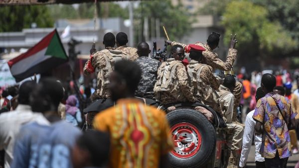 A Sudanese soldier flashes the victory sign at protesters during a sit-in outside the army headquarters in the capital Khartoum (AFP)