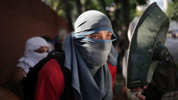 An opposition demonstrator clashes with soldiers loyal to Venezuelan President Nicolas Maduro  (AFP)