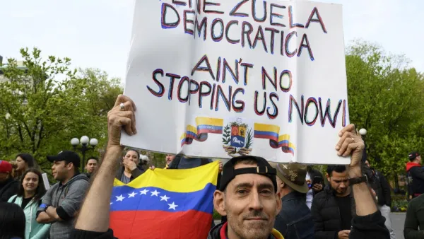 A man holds a sign as protesters gather at Union Square Park, in support of Venezuela's Operation Freedom and the Venezuelan opposition (AFP)