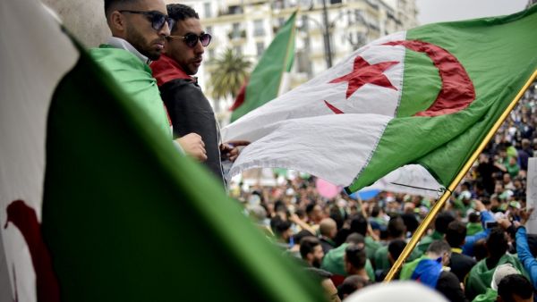 Algerian protesters wave a national flag as they take part in a demonstration in the capital Algiers (AFP)