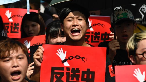Protesters display placards during a demonstration in Taipei  (AFP)