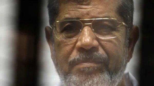 Egyptian ousted Islamist president Mohamed Morsi looks on from behind the defendants cage during is trial alongside 130 others on charges of organising jail breaks during the 2011 uprising that toppled strongman Hosni Mubarak (AFP)