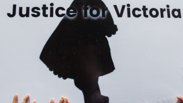 Protesters hold a sign during the demonstration demanding justice for a two-year-old who was raped and given the pseudonym "Victoria" in front of the Central Investigation Department (CID) in Yangon  (AFP)