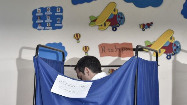 Greek Prime Minister Alexis Tsipras stands in a voting booth at a polling station during general elections in Athens, on July 7, 2019. Greek voters are casting their ballots in the country's first national election of the post-bailout era. Louisa GOULIAMAKI / AFP