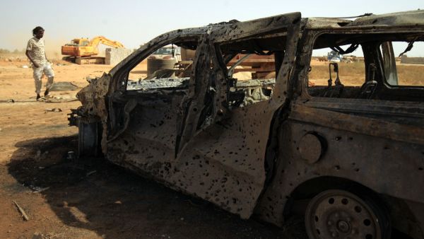 Damaged car at the site of a car bomb attack that targeted servicemen during the funeral of an ex-army commander in the Libyan city of Benghaz (AFP)
