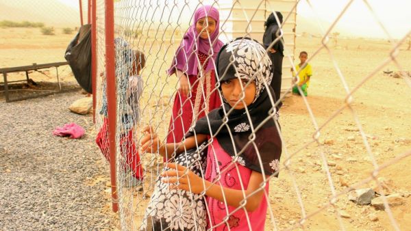 A displaced Yemeni girl looks on from a wire fence at a make-shift camp in the country's northern Hajjah province  (AFP)