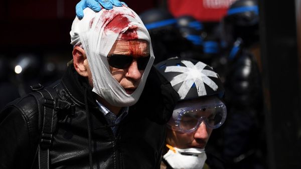 An injured protester is assisted by a street medic prior to the start of the annual May Day rally in Paris. A heady mix of labour unionists, 'yellow vest' demonstrators and hardline hooligans are expected to hit the streets today for Labour Day  (AFP)