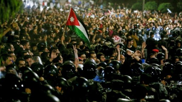 Protesters demonstrate outside the prime minister's office in Amman late on June 2, as security forces stand on alert /AFP