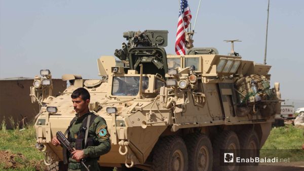 مسلح من الوحدات الكردية بجوار مدرعة أمريكية