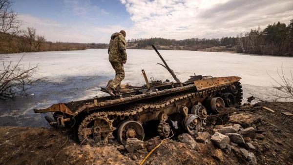 A Ukrainian serviceman stands near a destroyed Russian tank in the northeastern city of Trostianets, on March 29, 2022. Ukraine said on March 26, 2022 its forces had recaptured the town of Trostianets, near the Russian border, one of the first towns to fall under Moscow's control in its month-long invasion. (Photo by FADEL SENNA / AFP) US Says Russia 'Repositioning' Not Withdrawing From Ukraine